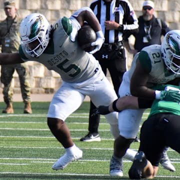 DeSoto's SaRod Baker (5) runs the ball during the first quarter of a playoff game on Saturday against Southlake Carroll.
