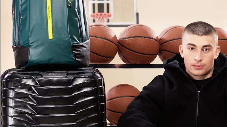 Payton Pritchard sits among his Samsonite luggage. | Photo via Samsonite.