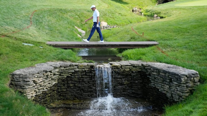 Jun 7, 2024; Dublin, Ohio, USA; Scottie Scheffler walks across a creek on the 17th hole during the second round of the Memorial Tournament at Muirfield Village Golf Club. Mandatory Credit: Adam Cairns-USA TODAY Sports