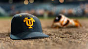 Jun 24, 2024; Omaha, NE, USA; A Tennessee Volunteers hat and glove lay on the field after defeating the Texas A&M Aggies in the championship at Charles Schwab Field Omaha. Mandatory Credit: Dylan Widger-Imagn Images