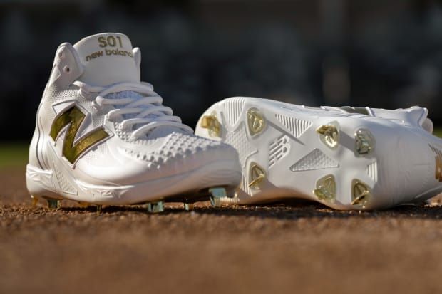 White and gold New Balance cleats.