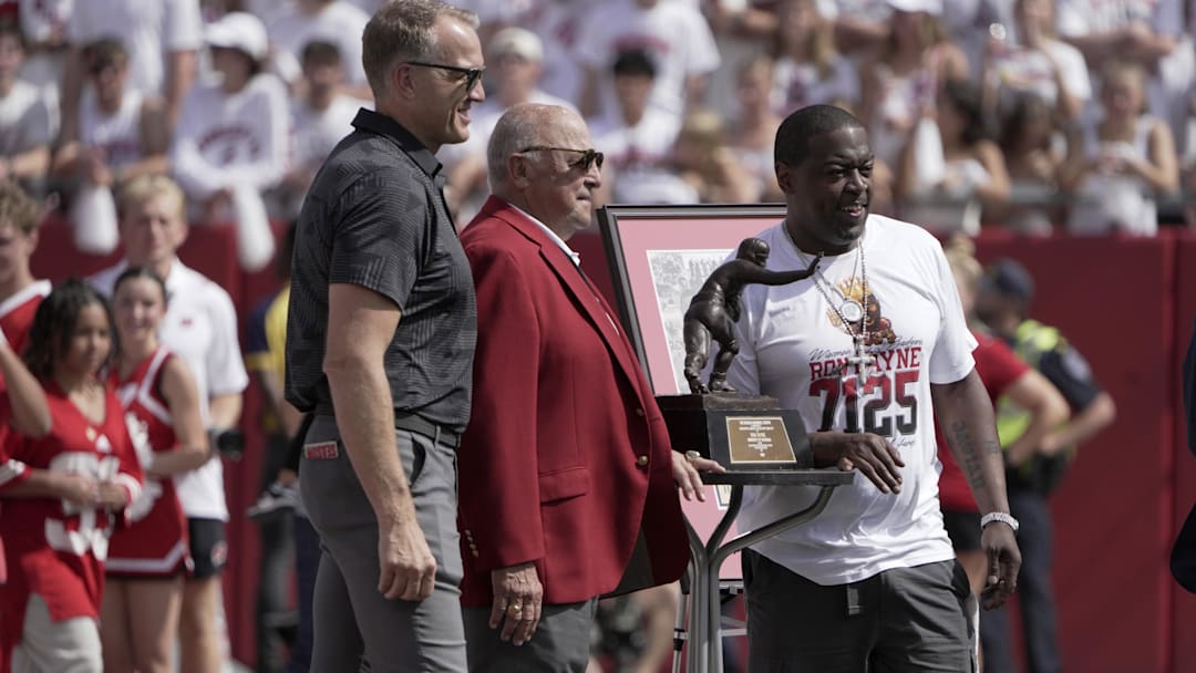 Wisconsin Badgers former running back and Heisman Trophy winner Ron Dayne, right, is honored during a game against the Alabama Crimson Tide at Camp Randall Stadium in Madison, Wis., on Sept. 14, 2024. Also shown are athletic director Chris McIntosh, left, and former head coach and athletic director Barry Alvarez. 