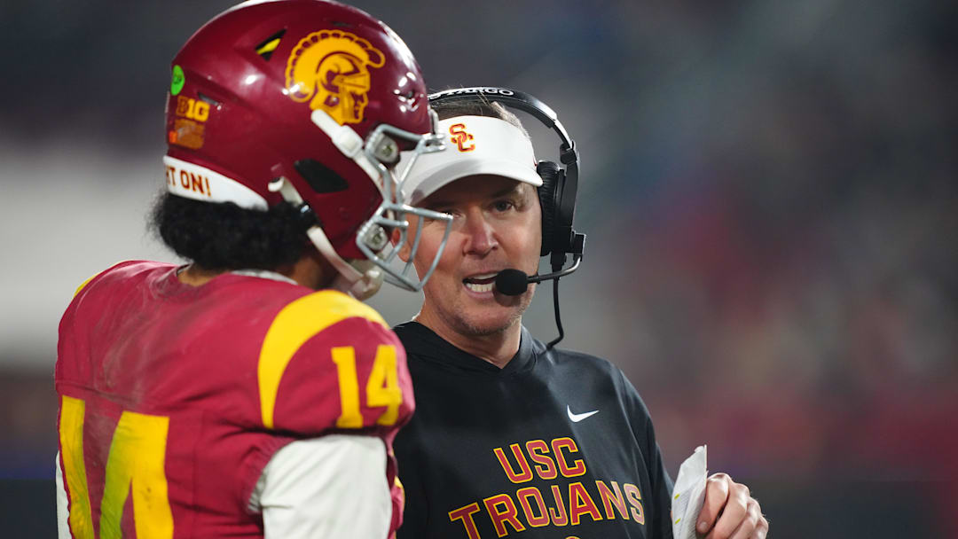 Nov 29, 2025; Los Angeles, California, USA; Southern California Trojans head coach Lincoln Riley (right) talks with quarterback Jayden Maiava (14) in the second half against the UCLA Bruins at United Airlines Field at Los Angeles Memorial Coliseum. Mandatory Credit: Kirby Lee-Imagn Images