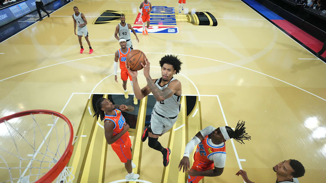 Spurs guard Dylan Harper drives to the basket as Thunder guard Lu Dort defends during an NBA Cup semifinal game in Las Vegas. Spurs guard Dylan Harper drives to the basket as Thunder guard Lu Dort defends during an NBA Cup semifinal game in Las Vegas.