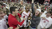 Wisconsin guard Kamari McGee (4) joins fans who stormed the court after their game Friday, November 15, 2024 at the Kohl Center in Madison, Wisconsin. Unranked Wisconsin upset Arizona 103-88.