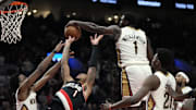 Oct 25, 2024; Portland, Oregon, USA; New Orleans Pelicans power forward Zion Williamson (1) blocks a shot by Portland Trail Blazers shooting guard Anfernee Simons (1) during the second half at Moda Center.