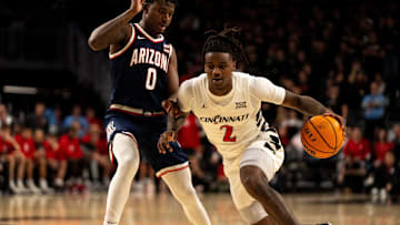 Cincinnati Bearcats guard Jizzle James (2) drives on Arizona Wildcats guard Jaden Bradley (0) in the second half of the NCAA basketball game at the Fifth Third Arena in Cincinnati on Saturday, January 4, 2025.