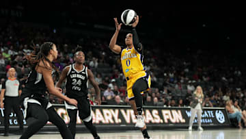 Jun 11, 2025; Las Vegas, Nevada, USA; Los Angeles Sparks guard Odyssey Sims (0) attempts to score a layup against Las Vegas Aces guard Jewell Loyd (24) and center Kiah Stokes (41) during the second half of a WNBA basketball game at Michelob Ultra Arena. Mandatory Credit: Lucas Peltier-Imagn Images
