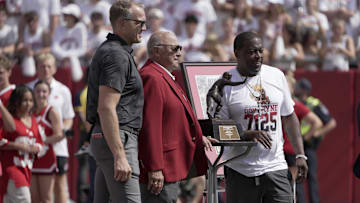 Wisconsin Badgers former running back and Heisman Trophy winner Ron Dayne, right, is honored during a game against the Alabama Crimson Tide at Camp Randall Stadium in Madison, Wis., on Sept. 14, 2024. Also shown are athletic director Chris McIntosh, left, and former head coach and athletic director Barry Alvarez. 