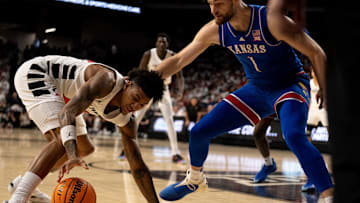 Cincinnati Bearcats forward Dillon Mitchell (23) grabs a loose ball as Kansas Jayhawks center Hunter Dickinson (1) guards him in the first half of the NCAA basketball game at Fifth Third Arena in Cincinnati on Saturday, January 11, 2025.