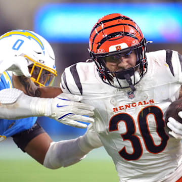 Nov 17, 2024; Inglewood, California, USA; Cincinnati Bengals running back Chase Brown (30) carries the ball against Los Angeles Chargers linebacker Daiyan Henley (0) in the second half at SoFi Stadium. Mandatory Credit: Kirby Lee-Imagn Images