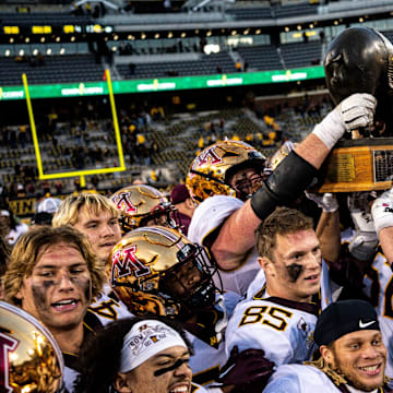 Minnesota players hold the Floyd of Rosedale trophy after defeating Iowa at Kinnick Stadium on Saturday, October 21, 2023 in Iowa City.