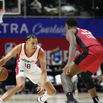 Jul 12, 2024; Las Vegas, NV, USA;  Washington Wizards forward Kyshawn George (18) controls the ball against Atlanta Hawks forward E.J. Liddell (32) during the second half at Thomas & Mack Center. Mandatory Credit: Lucas Peltier-Imagn Images