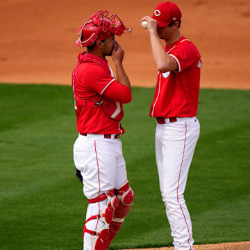 Cincinnati Reds catcher Luke Maile, left, talks with Cincinnati Reds starting pitcher Brandon Williamson (55) in the fourth inning during a MLB spring training baseball game, Sunday, Feb. 25, 2024, at Goodyear Ballpark in Goodyear, Ariz.