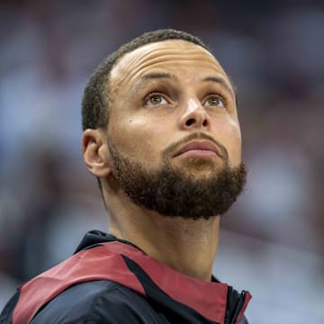 Golden State Warriors guard Stephen Curry looks on from the bench against the Minnesota Timberwolves.