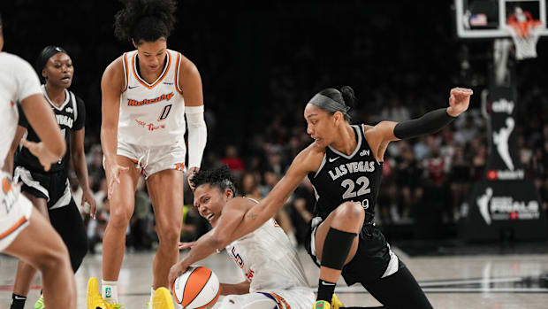 A photo of Alyssa Thomas and A'ja Wilson fighting for a bal