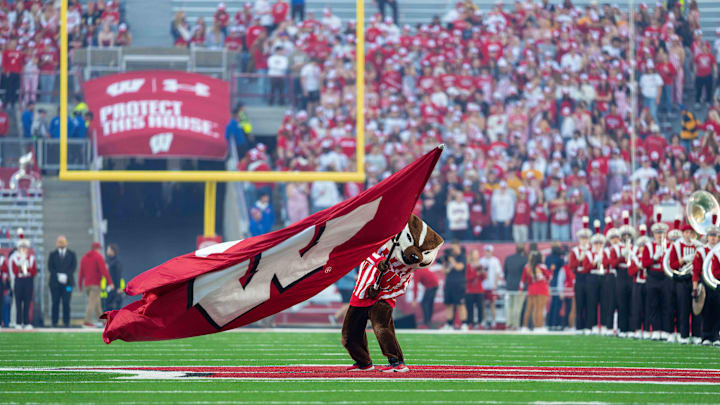 Oct 11, 2025; Madison, Wisconsin, USA; Bucky Badger waves a Wisconsin flag at mid field before a game between the Wisconsin Badgers and the Iowa Hawkeyes at Camp Randall Stadium. Mandatory Credit: Ross Harried-Imagn Images