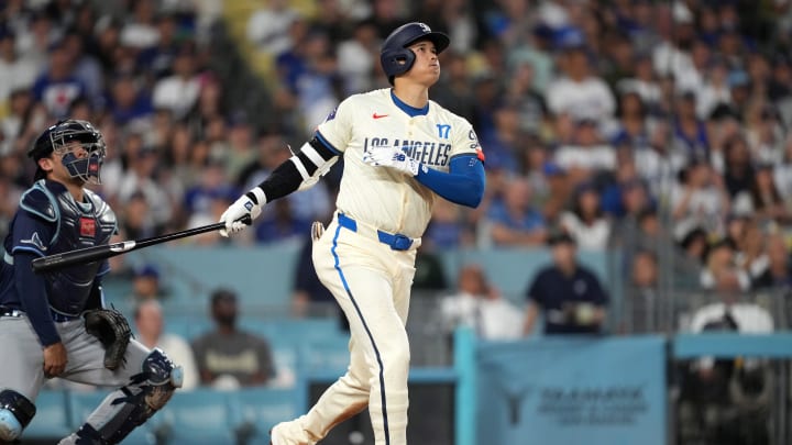 Aug 24, 2024; Los Angeles, California, USA; Los Angeles Dodgers designated hitter Shohei Ohtani (17) hits a two-run home run in the fifth inning as Tampa Bay Rays catcher Alex Jackson (28) watches at Dodger Stadium. Mandatory Credit: Kirby Lee-USA TODAY Sports