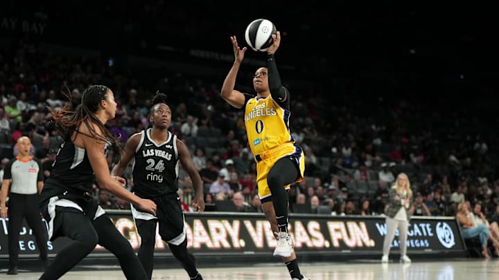 Jun 11, 2025; Las Vegas, Nevada, USA; Los Angeles Sparks guard Odyssey Sims (0) attempts to score a layup against Las Vegas Aces guard Jewell Loyd (24) and center Kiah Stokes (41) during the second half of a WNBA basketball game at Michelob Ultra Arena. Mandatory Credit: Lucas Peltier-Imagn Images
