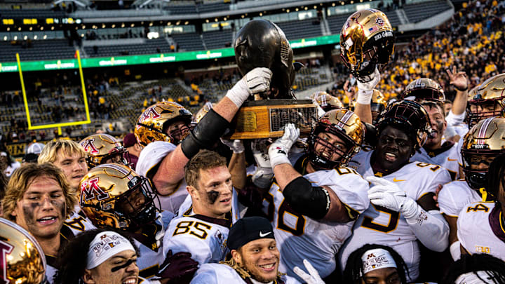 Minnesota players hold the Floyd of Rosedale trophy after defeating Iowa at Kinnick Stadium on Saturday, October 21, 2023 in Iowa City.