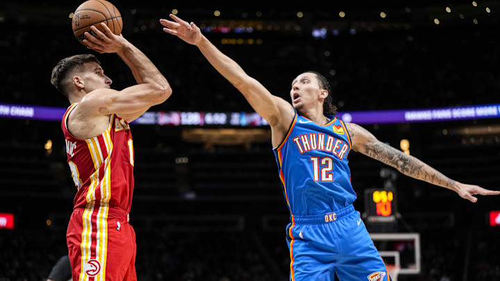 Jan 3, 2024; Atlanta, Georgia, USA; Atlanta Hawks guard Bogdan Bogdanovic (13) shoots the ball over Oklahoma City Thunder forward Lindy Waters III (12) during the second half at State Farm Arena. Mandatory Credit: Dale Zanine-Imagn Images