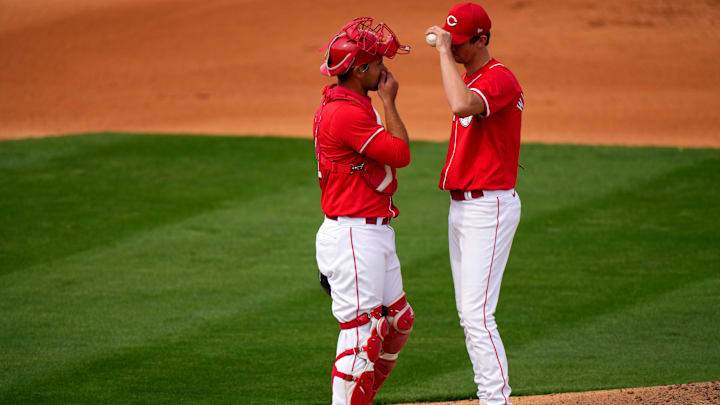 Cincinnati Reds catcher Luke Maile, left, talks with Cincinnati Reds starting pitcher Brandon Williamson (55) in the fourth inning during a MLB spring training baseball game, Sunday, Feb. 25, 2024, at Goodyear Ballpark in Goodyear, Ariz.