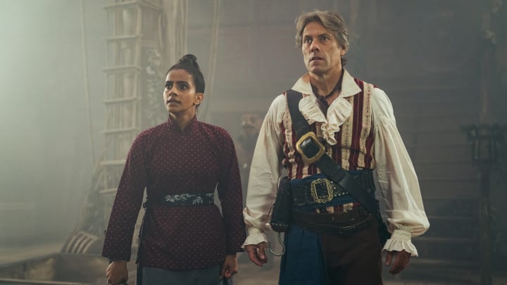 Yasmin Khan (MANDIP GILL) and Dan Lewis (JOHN BISHOP) - Doctor Who: Legend of the Sea Devils - Photo Credit: James Pardon/BBC Studios/BBC America