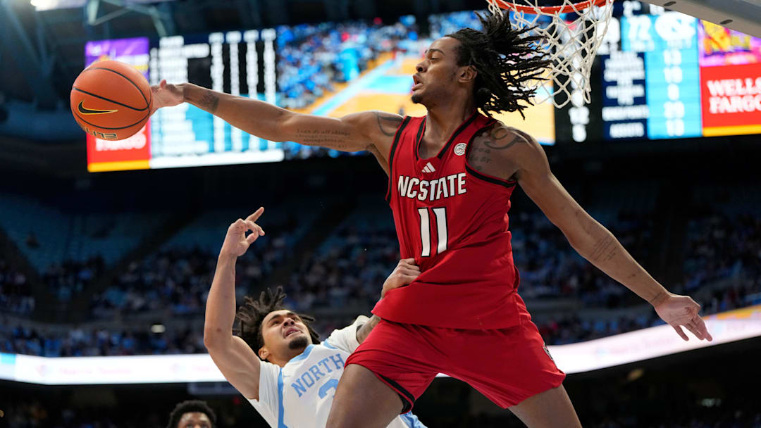 Feb 19, 2025; Chapel Hill, North Carolina, USA; North Carolina Tar Heels guard Elliot Cadeau (3) shoots as North Carolina State Wolfpack guard Dennis Parker Jr. (11) defends in the second half at Dean E. Smith Center. Mandatory Credit: Bob Donnan-Imagn Images