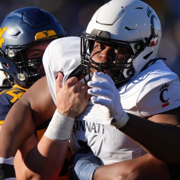 Cincinnati Bearcats defensive lineman Dontay Corleone (2) is double-teamed on a pass rush in the first quarter during an NCAA college football game between the Cincinnati Bearcats and the West Virginia Mountaineers, Saturday, Nov. 18, 2023, at Milan Puskar Stadium in Morgantown, W. Va.