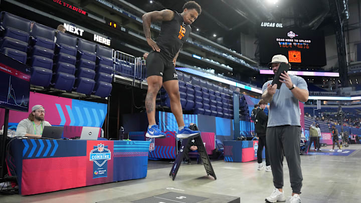 Feb 28, 2026; Indianapolis, IN, USA; Hawkin Dynamics specialist Trent Bassingthwaite (right) records force plate measurements of Kentucky running back Seth McGowan (RB12) during the NFL Scouting Combine at Lucas Oil Stadium. Mandatory Credit: Kirby Lee-Imagn Images