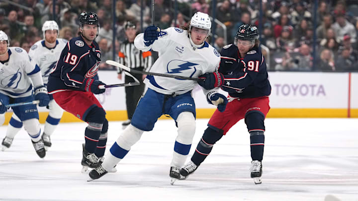 Blue Jackets and Lightning players battle for a loose puck. 