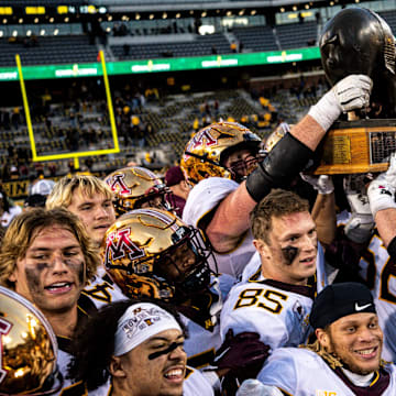 Minnesota players hold the Floyd of Rosedale trophy after defeating Iowa