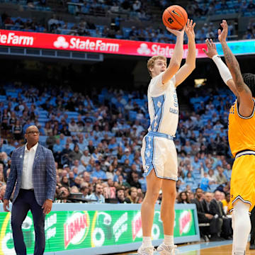 Dec 14, 2024; Chapel Hill, North Carolina, USA; North Carolina Tar Heels guard Cade Tyson (5) shoots a three point shot as La Salle Explorers guard Corey McKeithan (2) defends in the second half at Dean E. Smith Center. Mandatory Credit: Bob Donnan-Imagn Images