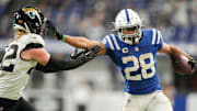Indianapolis Colts running back Jonathan Taylor (28) pushes off Jacksonville Jaguars safety Andrew Wingard (42) as he rushes the ball Sunday, Jan. 5, 2025, during a game against the Jacksonville Jaguars at Lucas Oil Stadium in Indianapolis.