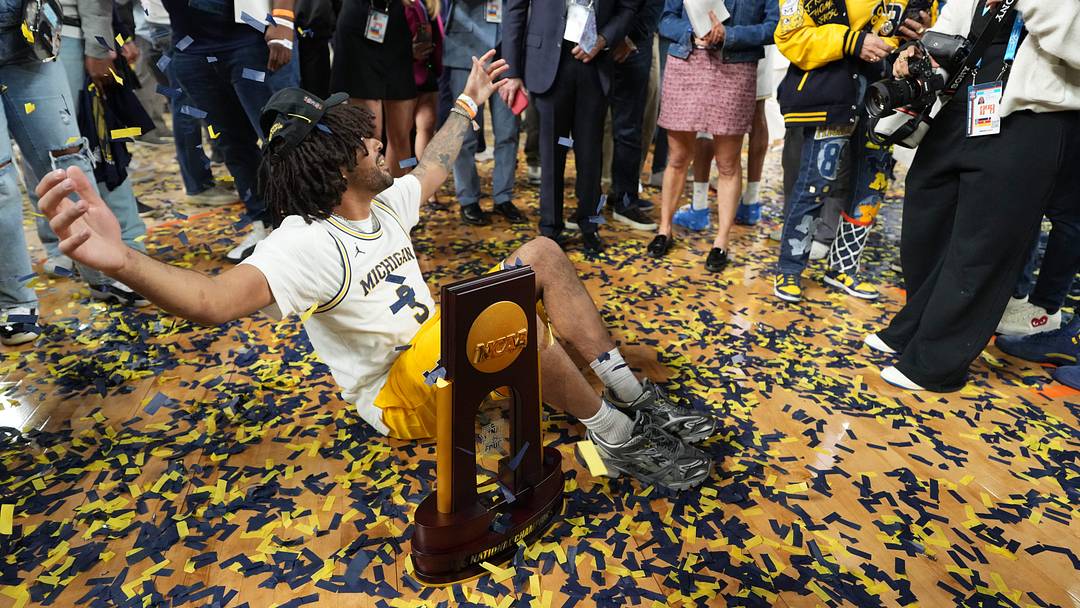 Apr 6, 2026; Indianapolis, IN, USA; Justin Cadeau, the brother of Michigan Wolverines guard Elliot Cadeau (3), with the National Championship Trophy after the National Championship of the Final Four of the men's 2026 NCAA Tournament at Lucas Oil Stadium. Mandatory Credit: Bob Donnan-Imagn Images Apr 6, 2026; Indianapolis, IN, USA; Justin Cadeau, the brother of Michigan Wolverines guard Elliot Cadeau (3), with the National Championship Trophy after the National Championship of the Final Four of the men's 2026 NCAA Tournament at Lucas Oil Stadium. Mandatory Credit: Bob Donnan-Imagn Images