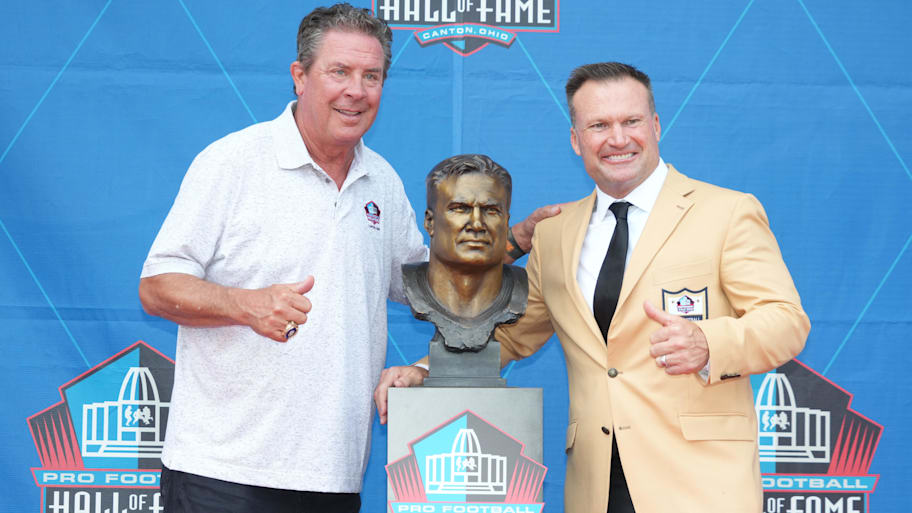 Miami Dolphins former linebacker Zach Thomas (right) poses with his bust and former quarterback Dan Marino during the 2023 Pro Football Hall of Fame Enshrinement at Tom Benson Hall of Fame Stadium. | Kirby Lee-Imagn Images