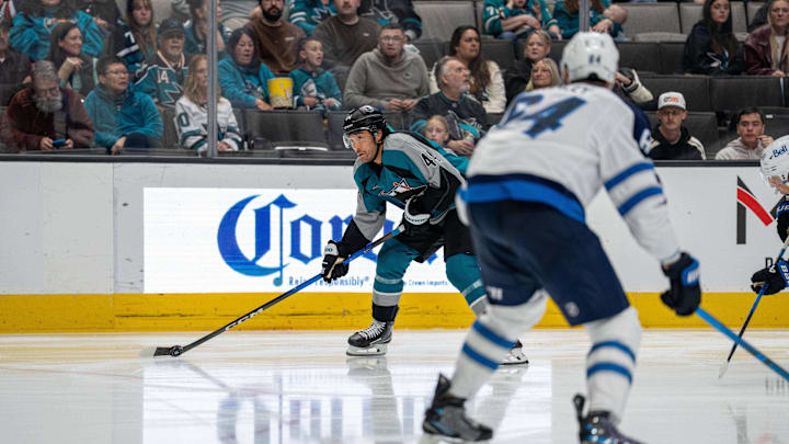 Feb 28, 2026; San Jose, California, USA; San Jose Sharks left wing Kiefer Sherwood (44) looks to pass the puck against Winnipeg Jets defenseman Dylan Samberg (54) during the second period at SAP Center at San Jose. Mandatory Credit: Neville E. Guard-Imagn Images