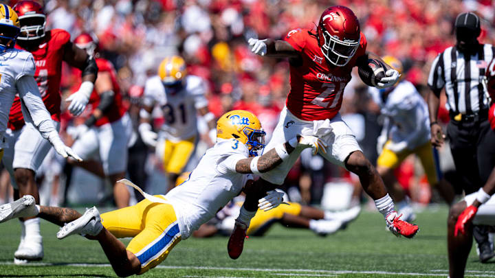 Cincinnati Bearcats running back Corey Kiner (21) breaks a tackle attempt by Pittsburgh Panthers defensive back Donovan McMillon (3) in the third quarter of the College Football game at Nippert Stadium in Cincinnati on Saturday, Sept. 7, 2024.