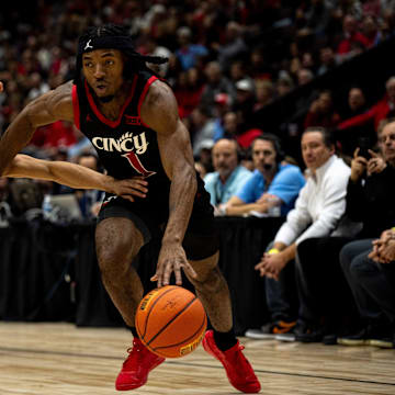 Cincinnati Bearcats guard Day Day Thomas (1) rives on Dayton Flyers guard Javon Bennett (0) in the first half of the NCAA men's basketball game between the Dayton Flyers and Cincinnati Bearcats at Heritage Bank Center in Cincinnati on Saturday, Dec. 16, 2023.