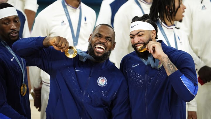 Aug 10, 2024; Paris, France; United States guard LeBron James (6) and centre Anthony Davis (14) celebrate with their gold medals on the podium after defeating France in the men's basketball gold medal game during the Paris 2024 Olympic Summer Games at Accor Arena. Mandatory Credit: Rob Schumacher-USA TODAY Sports