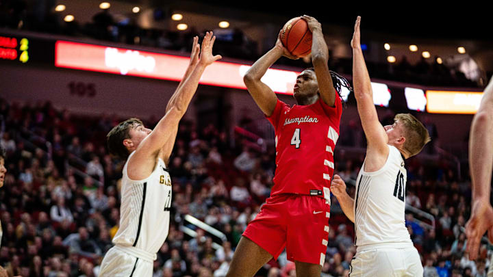 Assumption's Navon Shabazz shoots a shot over Waverly Shell Rock's Luke Frazell (left) and Waverly Shell Rock's Jude Landers (right) Friday, March 8, 2024, at Wells Fargo Arena.