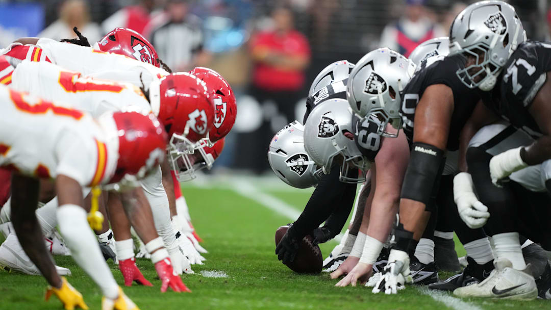 Jan 4, 2026; Paradise, Nevada, USA; Helmets at the line of scrimmage as Las Vegas Raiders long snapper Jacob Bobenmoyer (50) snaps the ball against the Kansas City Chiefs in the first half at Allegiant Stadium. Mandatory Credit: Kirby Lee-Imagn Images