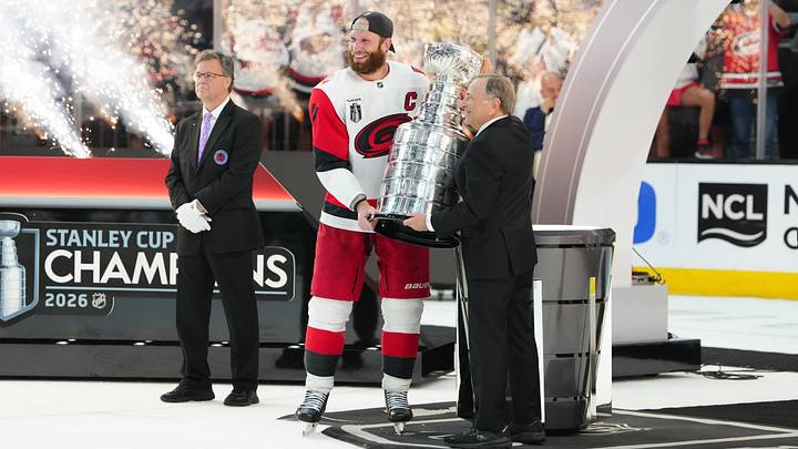 Jun 14, 2026; Las Vegas, Nevada, USA; Carolina Hurricanes center Jordan Staal (11) picks up the the Stanley Cup from Commissioner of the NHL Gary Bettman after defeating the Vegas Golden Knights in game six of the 2026 Stanley Cup Final at T-Mobile Arena. Mandatory Credit: Stephen R. Sylvanie-Imagn Images