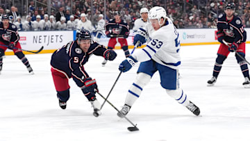 Blue Jackets defenseman Denton Mateychuk tries to break up Maple Leafs forward Easton Cowan's shot. 