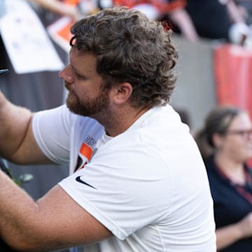 Cincinnati Bengals center Ted Karras (64) signs his autograph for fans before NFL preseason game between the Cincinnati Bengals and the Indianapolis Colts at Paycor Stadium in Cincinnati on Thursday, Aug. 22, 2024.