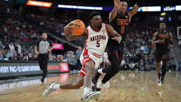 Mar 14, 2024; Las Vegas, NV, USA; Arizona Wildcats guard KJ Lewis (left) dribbles the ball against Southern California Trojans guard Boogie Ellis in the first half at T-Mobile Arena. 