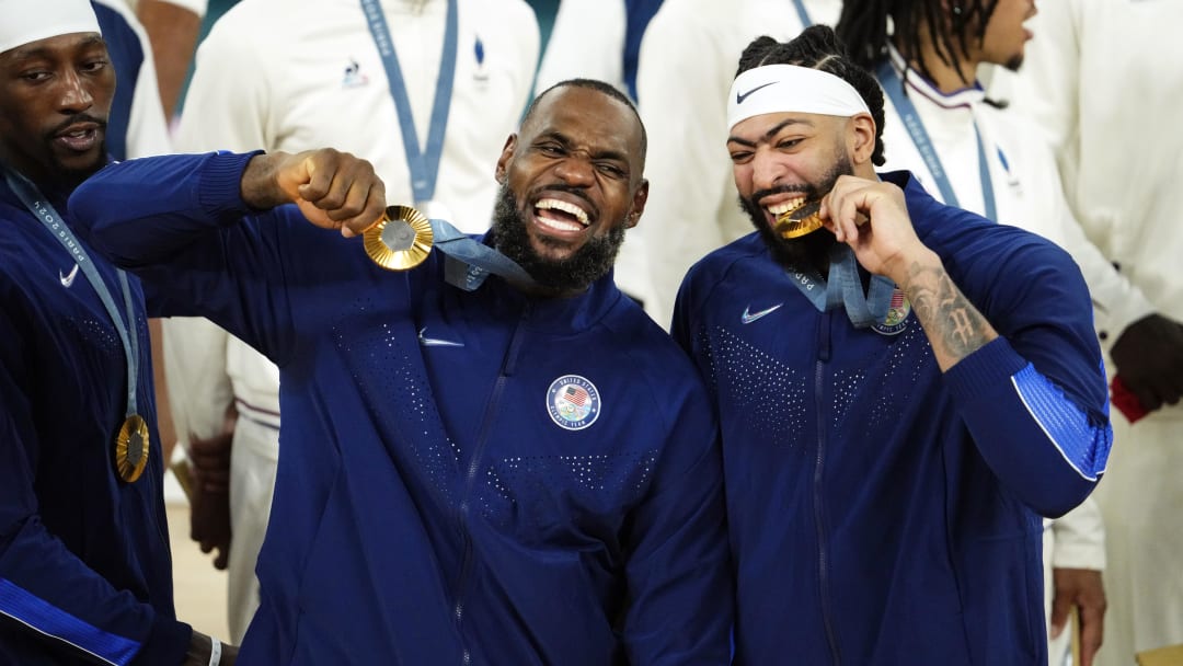 Aug 10, 2024; Paris, France; United States guard LeBron James (6) and centre Anthony Davis (14) celebrate with their gold medals on the podium after defeating France in the men's basketball gold medal game during the Paris 2024 Olympic Summer Games at Accor Arena. Mandatory Credit: Rob Schumacher-USA TODAY Sports