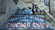 Fans walk upstairs with a Chicago Cubs decoration before the game against the Los Angeles Dodgers during the Tokyo Series at Tokyo Dome. 