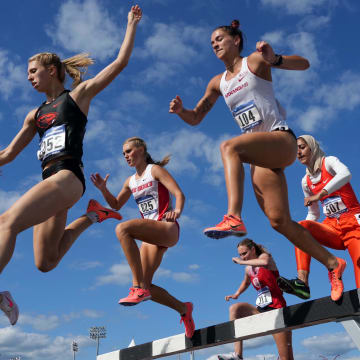 Gracie Hyde of Arkansas (104) races over the water jump in the women's steeplechase during the NCAA West Preliminary in College Station, Texas.