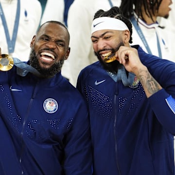 Aug 10, 2024; Paris, France; United States guard LeBron James (6) and centre Anthony Davis (14) celebrate with their gold medals on the podium after defeating France in the men's basketball gold medal game during the Paris 2024 Olympic Summer Games at Accor Arena. Mandatory Credit: Rob Schumacher-Imagn Images